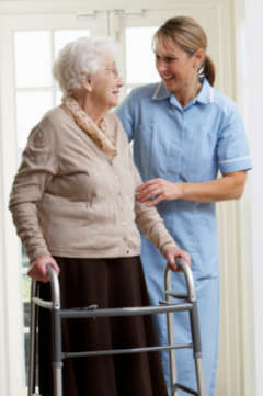 nurse helping woman with walker 