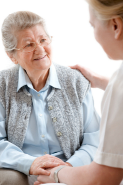 older woman speaking with a nurse 