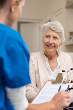 older woman speaking with nurse 