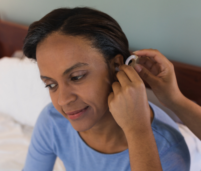 woman putting in hearing aid