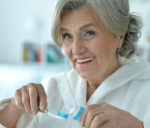 senior woman brushing her teeth