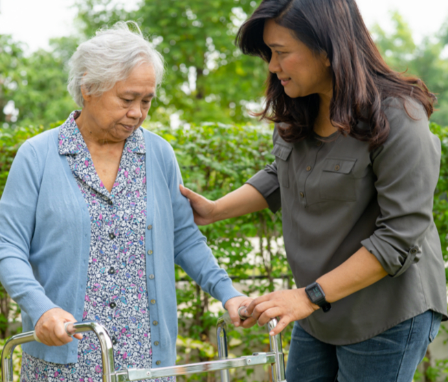 caregiver helping woman with walker