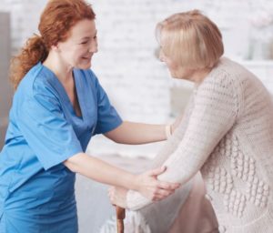 nurse helping elderly lady walk