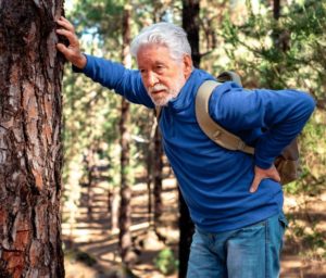 senior man hiking with back pain