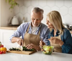 happy senior couple cooking healthy meal