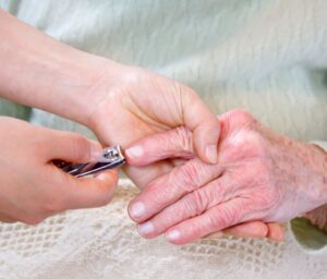 cutting senior woman's fingernails