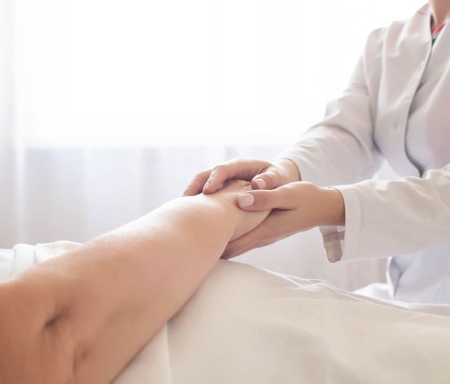 doctor holding hand of elderly patient